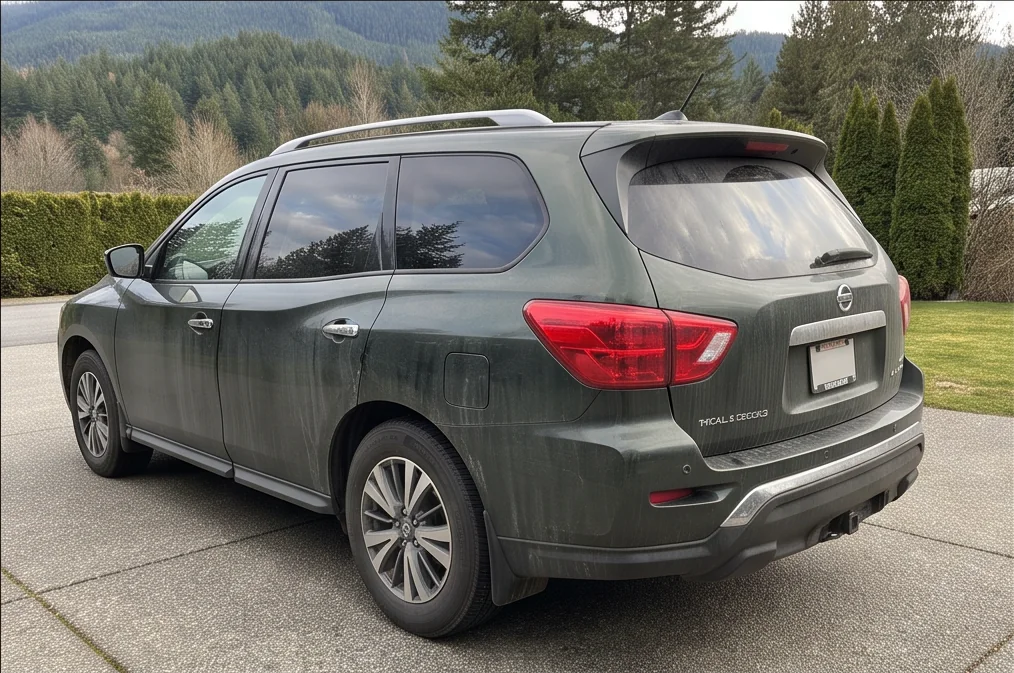 A dark green SUV with road film before ceramic coating preparation in Chilliwack, BC