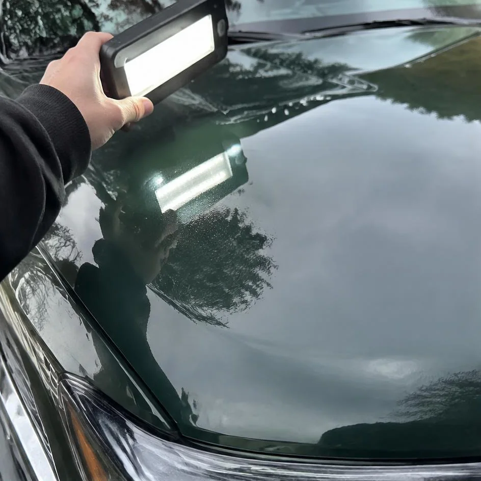 Dark green hood reflecting a work light after machine polishing in Chilliwack, BC