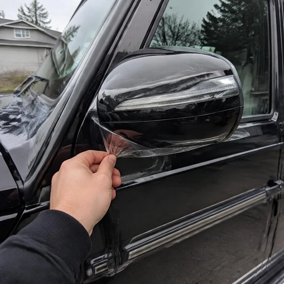 Protection film edge being tucked around a wing mirror in Chilliwack, BC